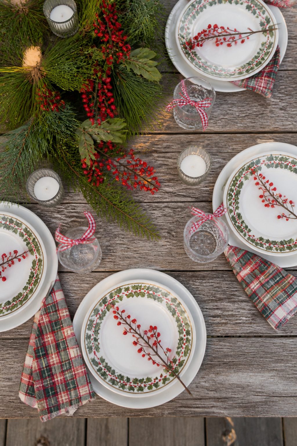 9 Outdoor Christmas Table Decoration Ideas for 2026 11 Layered plates and napkins arranged on an outdoor dining table.