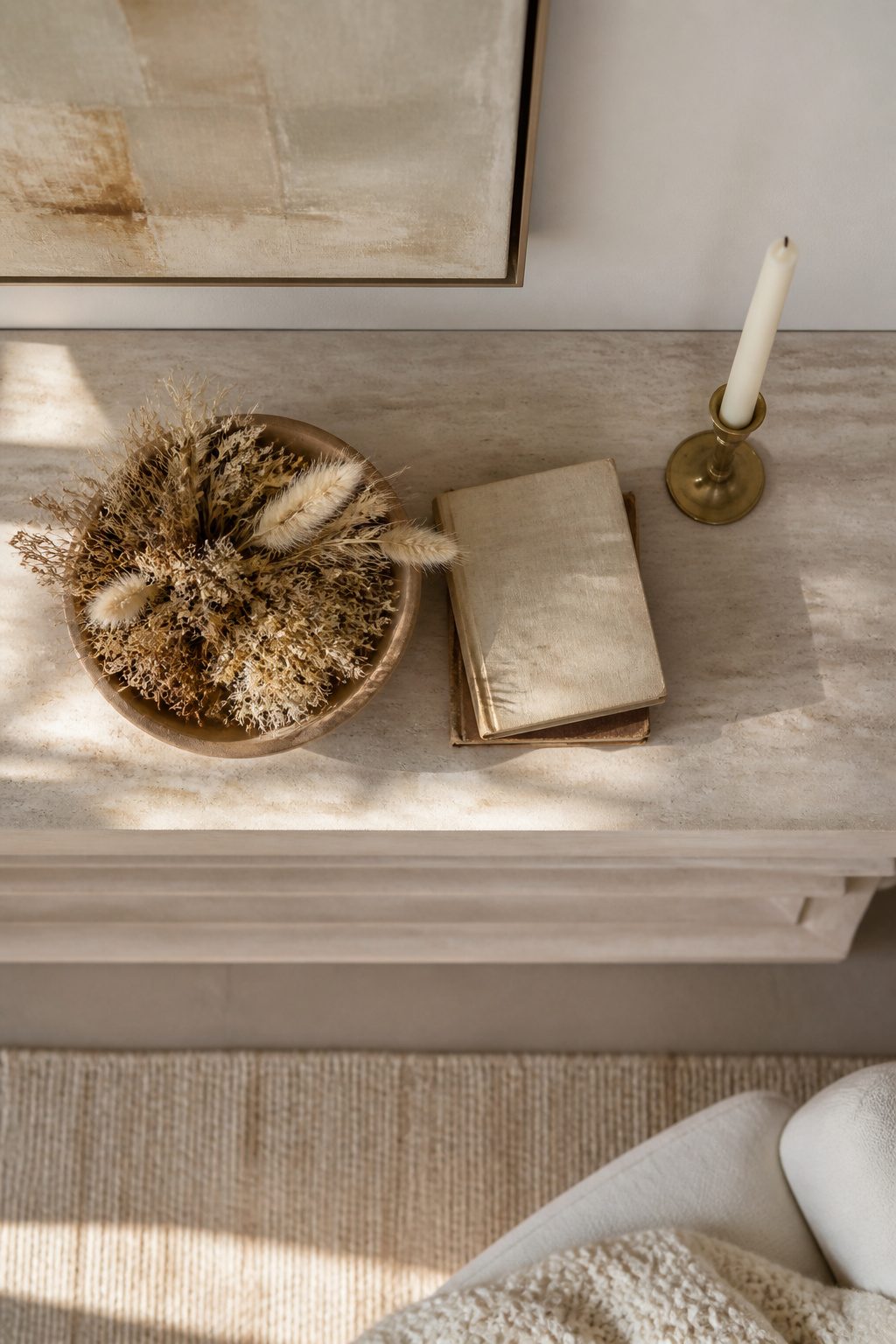 A simple mantel with a mirror, a vase, and one candle.